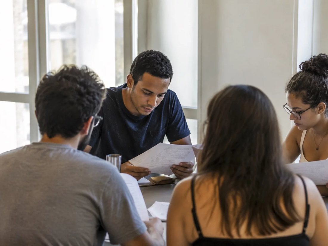 Profissionais numa sala de reunião clara, uma pessoa explicando algo