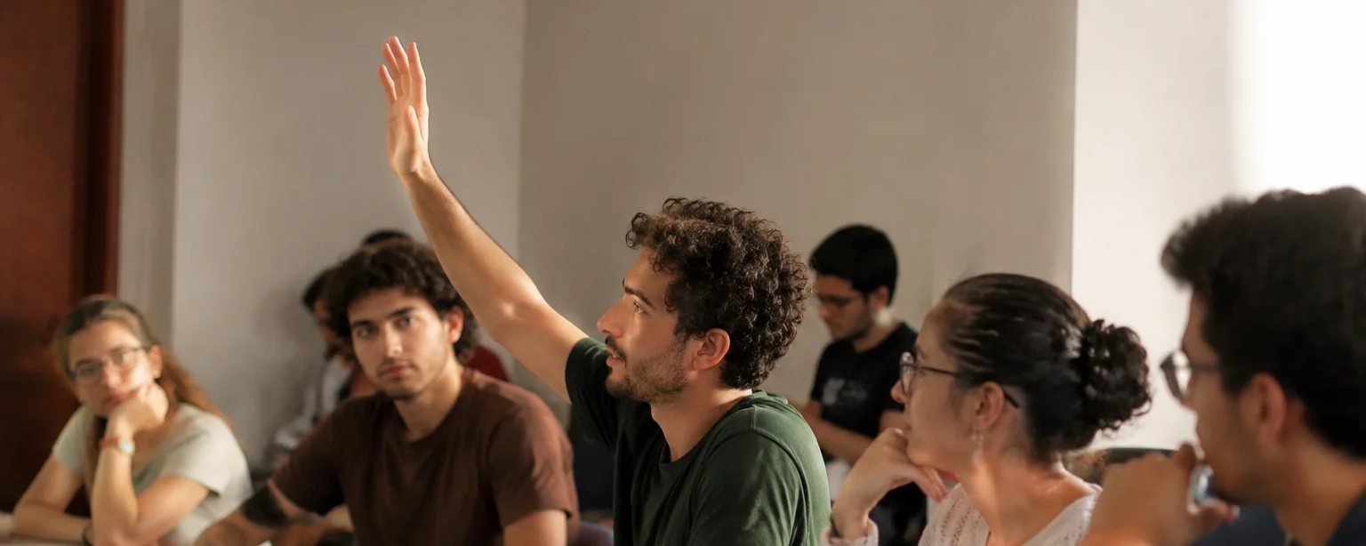Três participantes conversando na ponta de uma mesa comprida